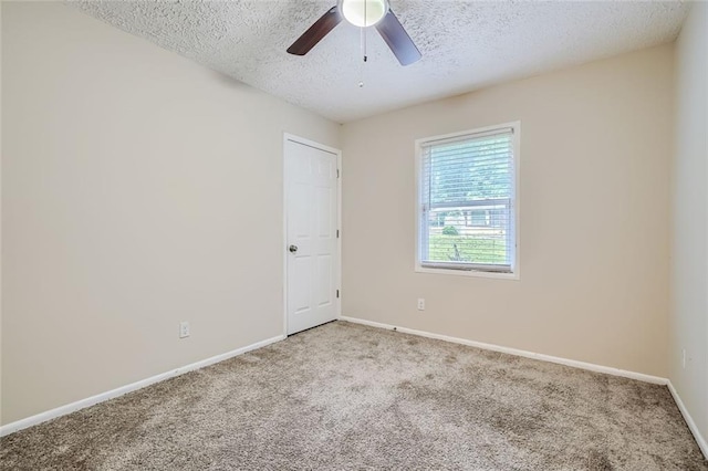 carpeted spare room featuring a textured ceiling and ceiling fan