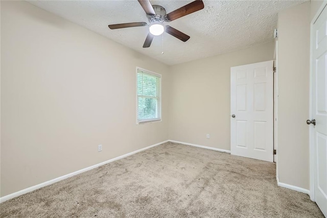 carpeted empty room with ceiling fan and a textured ceiling