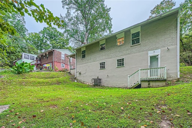 rear view of house featuring a lawn