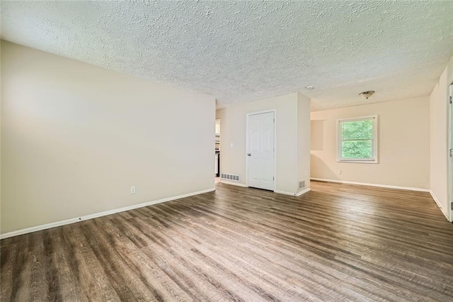 unfurnished room with a textured ceiling and dark hardwood / wood-style floors