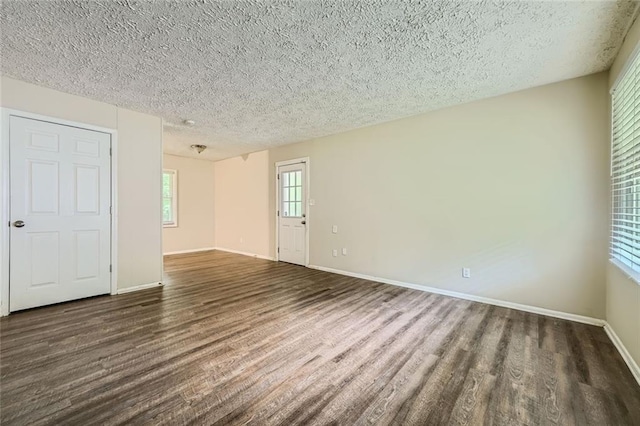 unfurnished room with dark hardwood / wood-style floors and a textured ceiling