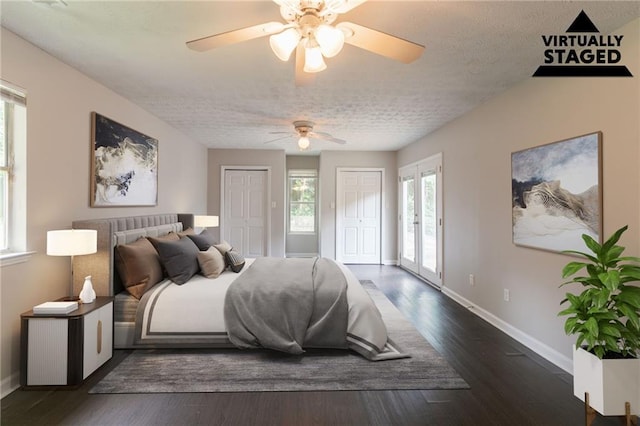 1615 Enchanted Forest Dr, Conley, GA 30288 - bedroom featuring baseboards, a textured ceiling, two closets, and dark wood-style floors