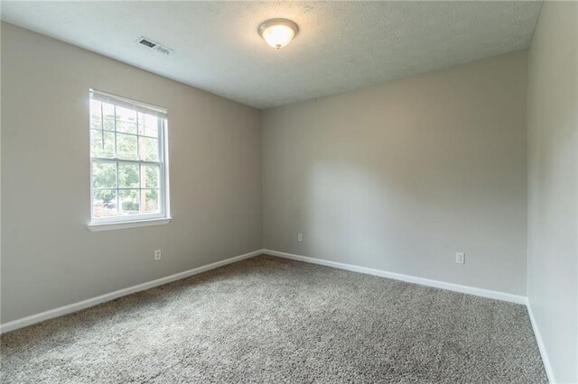 1615 Enchanted Forest Dr, Conley, GA 30288 - carpeted spare room featuring baseboards, a textured ceiling, and visible vents