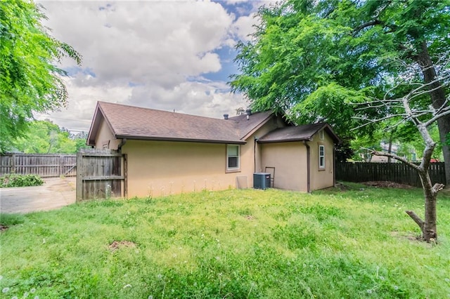 1615 Enchanted Forest Dr, Conley, GA 30288 - back of property featuring a yard, central AC unit, a fenced backyard, and stucco siding