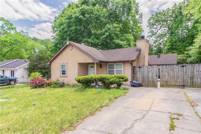 1615 Enchanted Forest Dr, Conley, GA 30288 - view of front of house featuring fence, stucco siding, a chimney, and a front yard