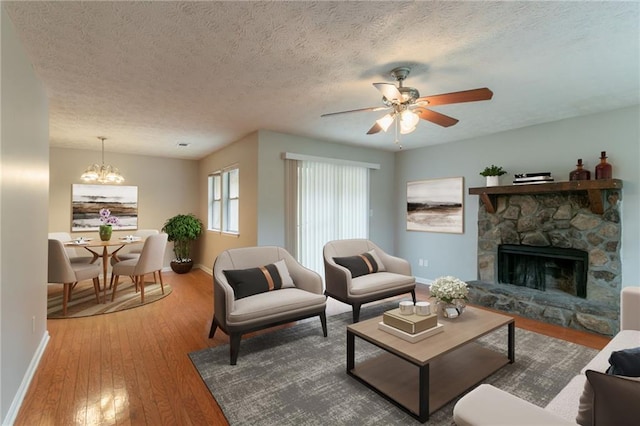 1615 Enchanted Forest Dr, Conley, GA 30288 - living area featuring baseboards, ceiling fan with notable chandelier, a stone fireplace, and hardwood / wood-style flooring
