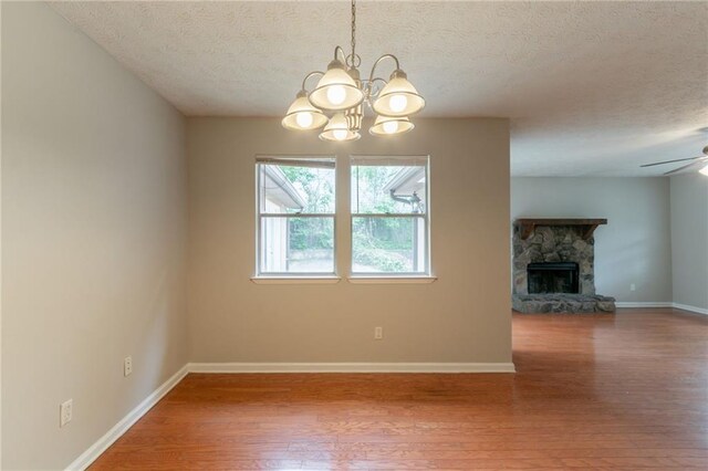 1615 Enchanted Forest Dr, Conley, GA 30288 - unfurnished living room featuring a textured ceiling, ceiling fan with notable chandelier, wood finished floors, and a fireplace