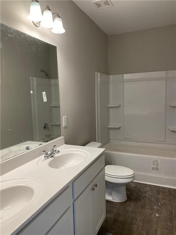 full bathroom with shower / tub combination, hardwood / wood-style floors, vanity, and toilet