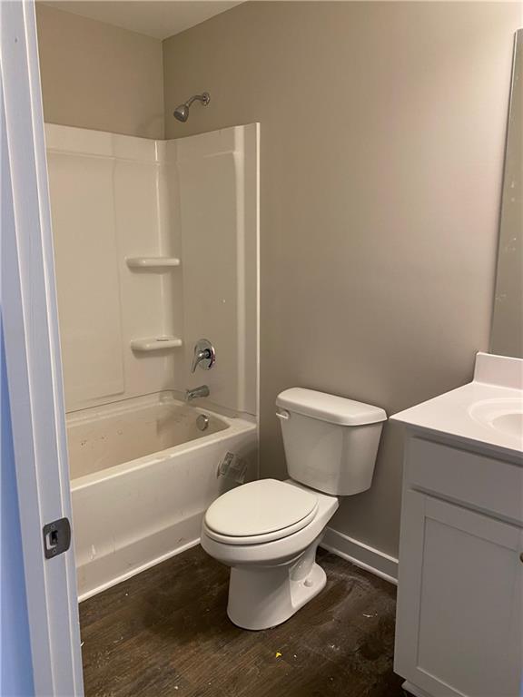 full bathroom featuring shower / tub combination, vanity, hardwood / wood-style flooring, and toilet