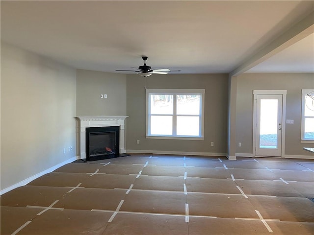 unfurnished living room featuring plenty of natural light and ceiling fan