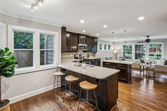 1735 Jobeth Ave SE, Atlanta, GA 30316 - kitchen featuring stainless steel appliances, dark brown cabinets, dark wood-type flooring, a kitchen breakfast bar, and recessed lighting