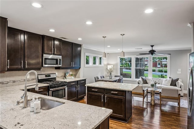 1735 Jobeth Ave SE, Atlanta, GA 30316 - kitchen with appliances with stainless steel finishes, dark brown cabinetry, light stone counters, recessed lighting, and ornamental molding