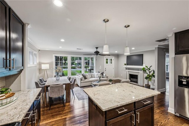 1735 Jobeth Ave SE, Atlanta, GA 30316 - kitchen with stainless steel fridge, ornamental molding, dark brown cabinets, pendant lighting, and dark wood finished floors