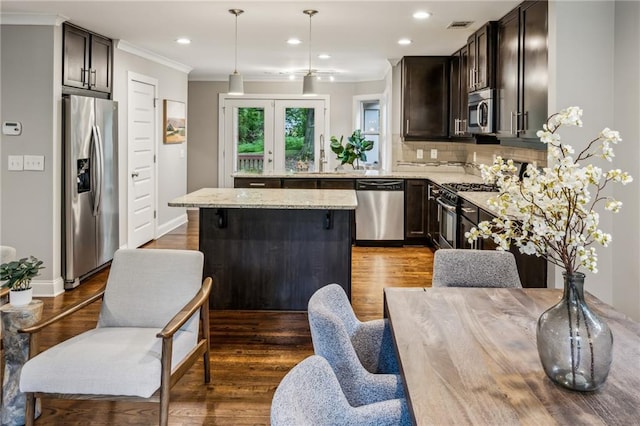 1735 Jobeth Ave SE, Atlanta, GA 30316 - kitchen featuring appliances with stainless steel finishes, ornamental molding, wood finished floors, a kitchen island, and recessed lighting