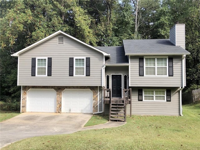 split foyer home with a front yard and a garage