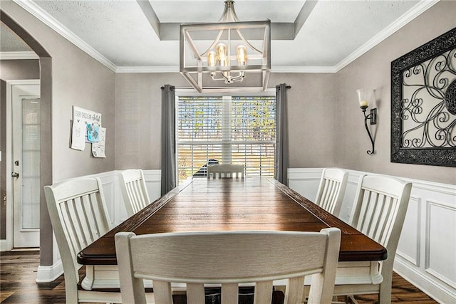 dining room with arched walkways, a wainscoted wall, a chandelier, and dark wood-type flooring