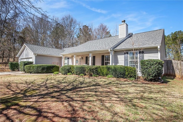 ranch-style home with a shingled roof, fence, a front yard, a chimney, and a garage