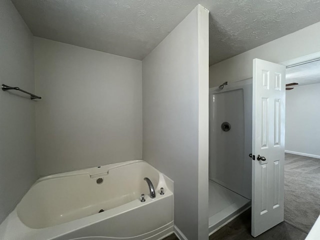 bathroom with independent shower and bath and a textured ceiling