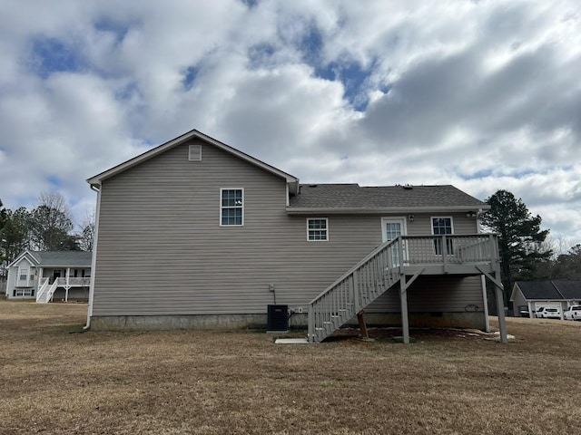 rear view of house featuring a wooden deck, a yard, and central AC