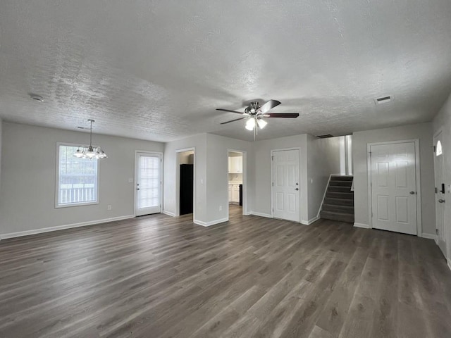 unfurnished living room with dark hardwood / wood-style flooring, ceiling fan with notable chandelier, and a textured ceiling