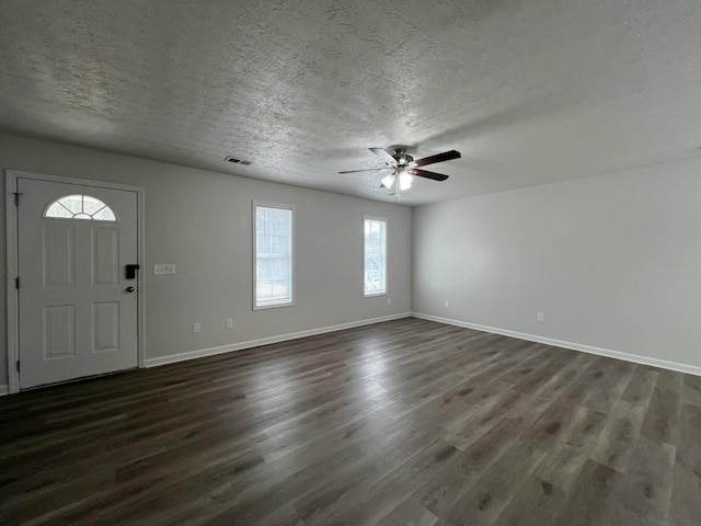 foyer entrance featuring ceiling fan, dark wood-type flooring, and a textured ceiling