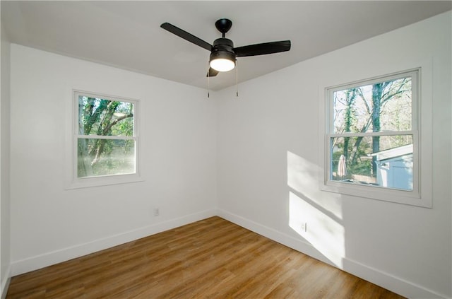 unfurnished room with ceiling fan, hardwood / wood-style floors, and a healthy amount of sunlight