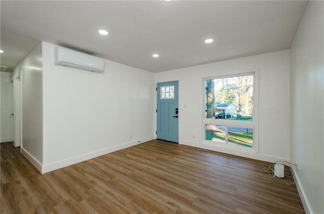 foyer entrance featuring wood-type flooring and an AC wall unit