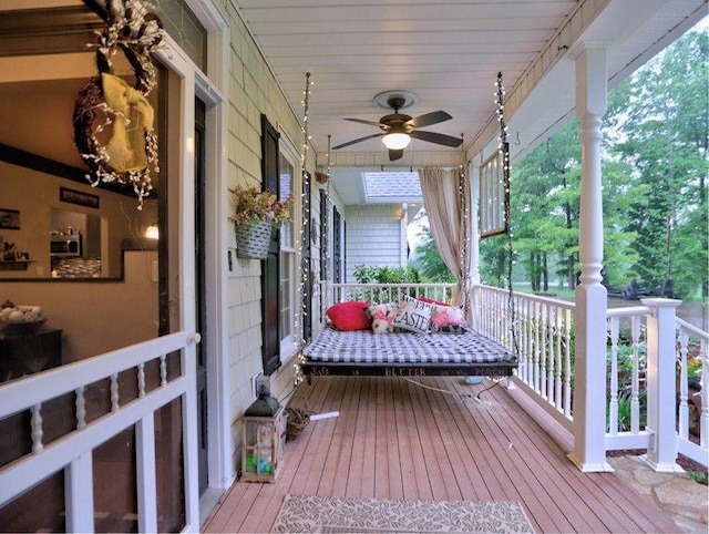 wooden terrace with a ceiling fan and covered porch
