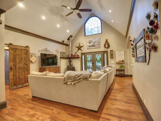 living area featuring french doors, high vaulted ceiling, a ceiling fan, and light wood-style flooring