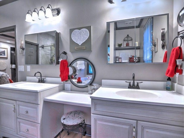bathroom featuring two vanities, a sink, and a stall shower