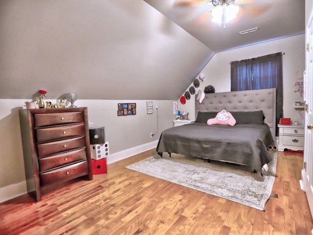 bedroom with baseboards, ceiling fan, wood finished floors, and lofted ceiling