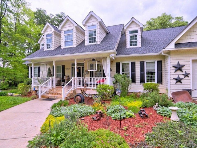 cape cod house featuring a shingled roof and covered porch