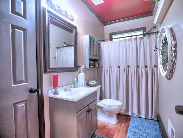 bathroom with crown molding, vanity, toilet, wood finished floors, and visible vents