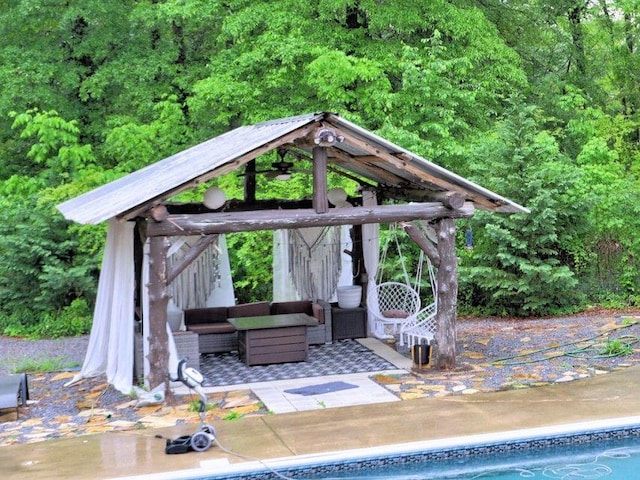 exterior space with a gazebo, a view of trees, an outdoor pool, and an outdoor hangout area