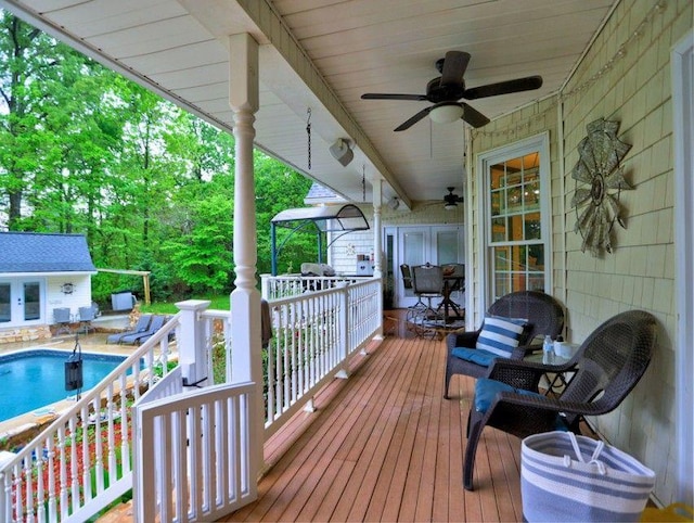 deck with an outdoor structure, a ceiling fan, an outdoor pool, and a grill