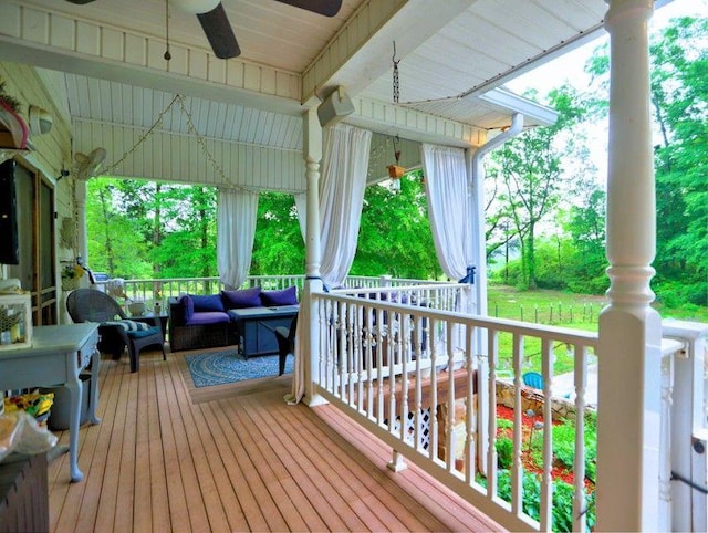 wooden deck featuring ceiling fan, outdoor lounge area, and covered porch