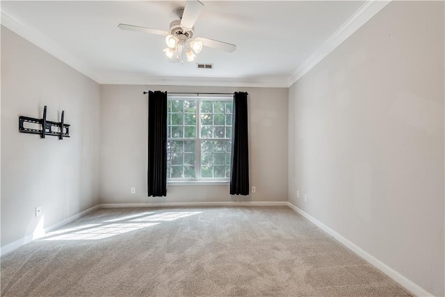 spare room featuring carpet floors, baseboards, visible vents, and ornamental molding