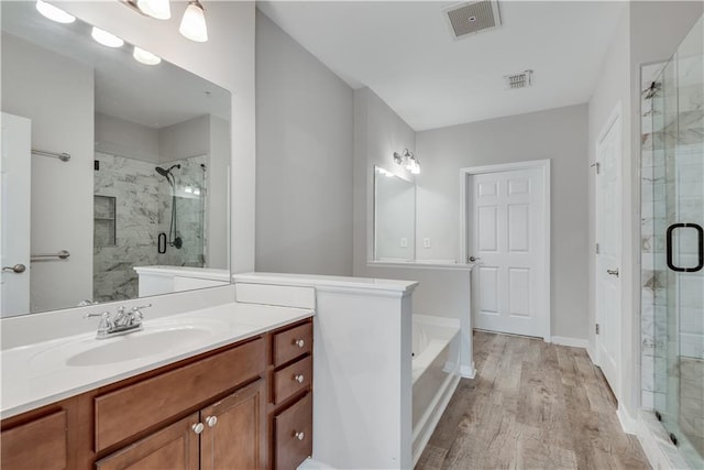 bathroom featuring a stall shower, visible vents, and wood finished floors