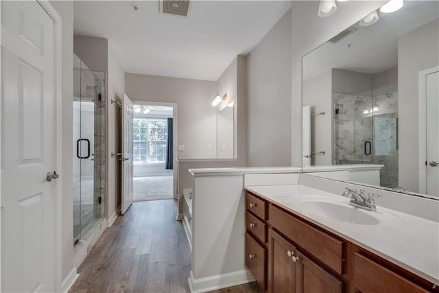 full bath featuring a stall shower, visible vents, vanity, and wood finished floors