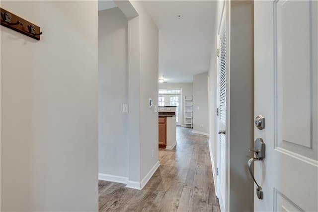 entryway featuring baseboards and light wood finished floors