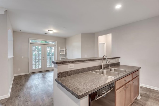 kitchen with a kitchen island with sink, wood finished floors, a sink, french doors, and dishwasher