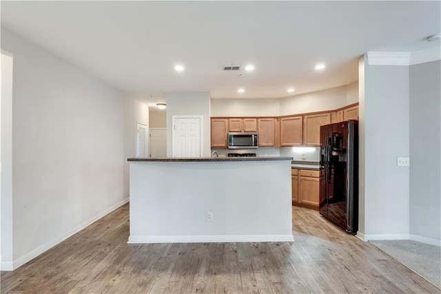 kitchen with baseboards, stainless steel microwave, freestanding refrigerator, light wood-type flooring, and recessed lighting