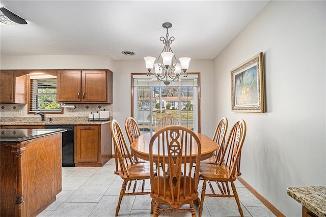 dining room with an inviting chandelier, visible vents, light tile patterned floors, and baseboards