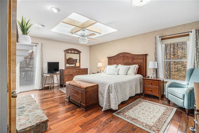 bedroom with a skylight, a ceiling fan, and wood finished floors