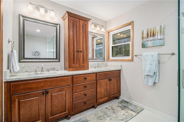 bathroom featuring double vanity, a sink, and baseboards