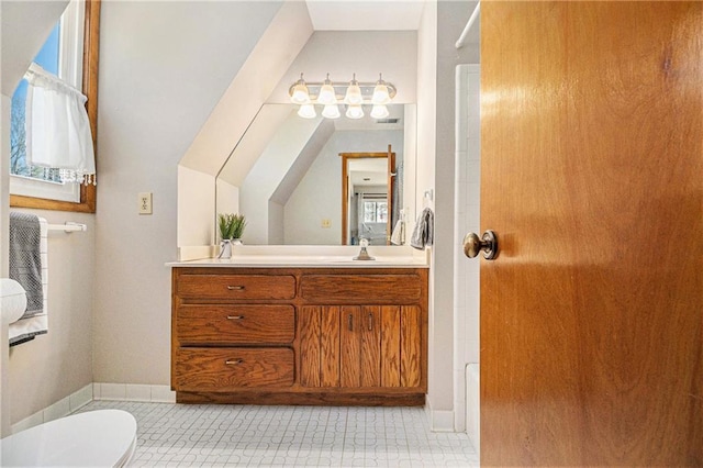 bathroom with toilet, lofted ceiling, and vanity