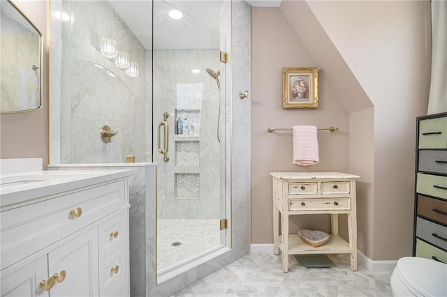 bathroom with toilet, a stall shower, vanity, and baseboards