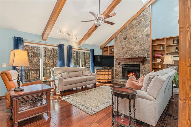 living room featuring a ceiling fan, wood finished floors, a stone fireplace, high vaulted ceiling, and beam ceiling