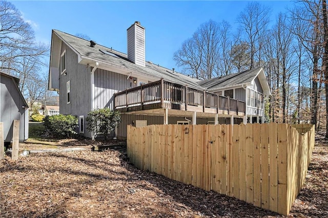 rear view of house with a chimney and a wooden deck