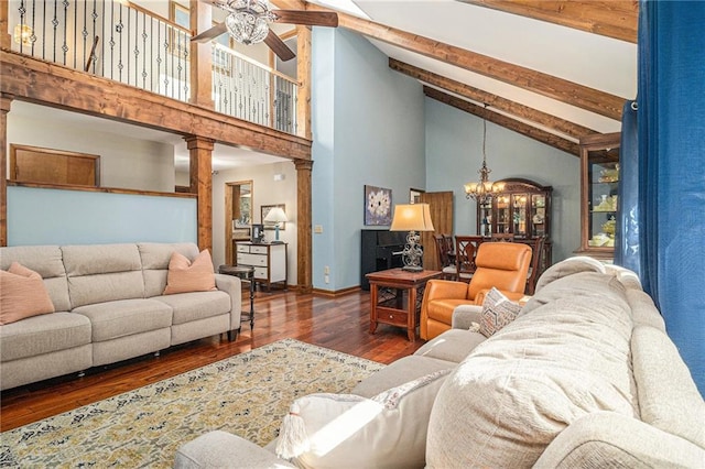 living room featuring wood finished floors, ornate columns, high vaulted ceiling, beam ceiling, and ceiling fan with notable chandelier